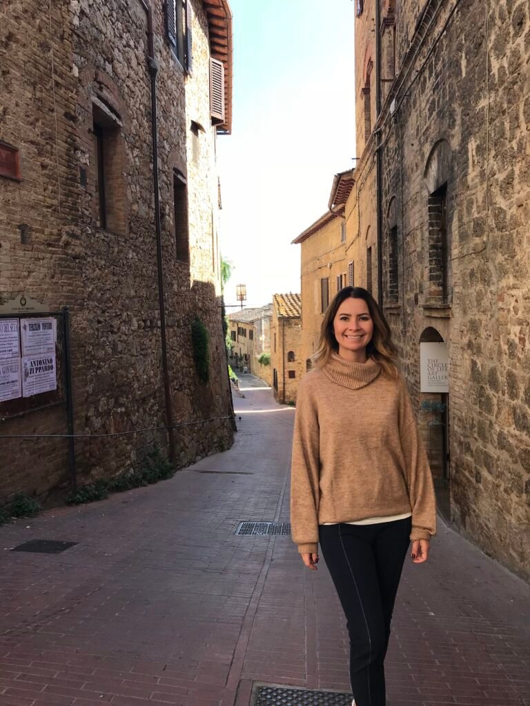 Mariana Tupan caminhando por uma rua de pedra na Itália